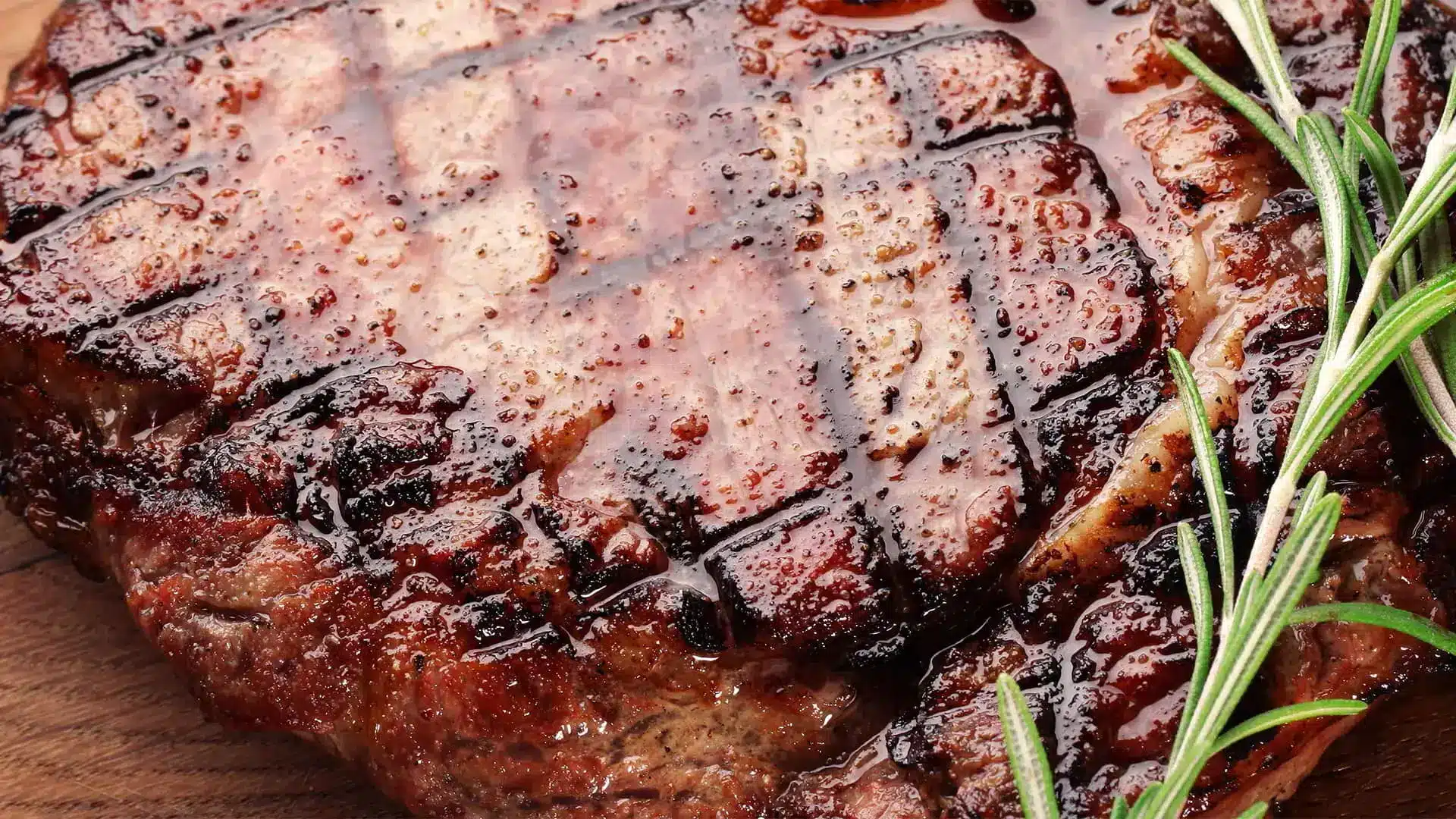 Grilled steak resting with a sprig of rosemary